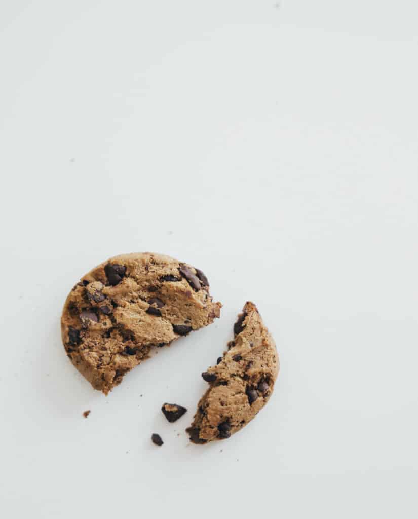Bolacha de chocolate partida em cima da mesa com migalhas